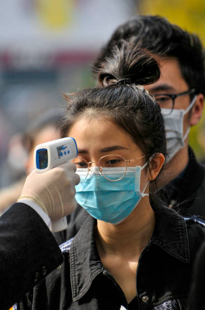 Wearing masks, people lined up for temperature checks before entering the mall 、Starbacks and hotel in Chengdu,China Chengdu/China-Feb.2020: New type coronavirus pneumonia in Wuhan has been spreading into many cities in China. Wearing masks, people lined up for temperature checks before entering the Chunxi Road, downtown mall in Chengdu,China,which is Chengdu's most famous shopping street and has numerous stores for shopping. chengdu photos stock pictures, royalty-free photos & images