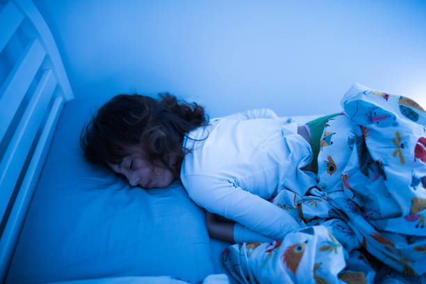 istock Small 11 year old girl sleeping in bed on a stomach. 1207956715