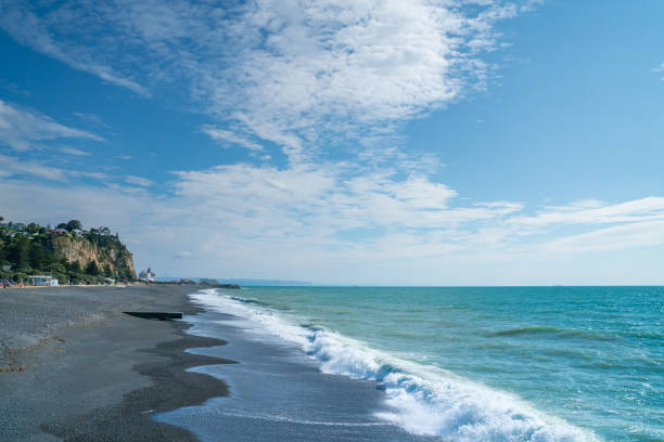 Napier - New Zealand - February 15 2020; View along grey stony beach looking north with Port in background.