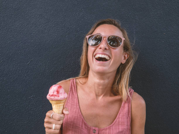 istock Happy woman eating ice cream on background 1207967201