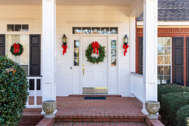 Front Porch and door decorated for the Christmas holiday season Residential home front door decorated for Christmas front porch stock pictures, royalty-free photos & images