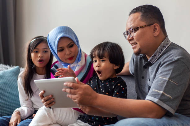família jovem brincalhão surfando na rede em tablet digital - digital tablet family father offspring - fotografias e filmes do acervo