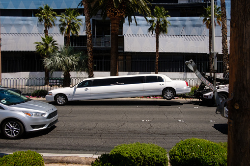 Las Vegas, Nevada, USA - May 16, 2018: A long white limo is pulled by a tow truck along the Las Vegas Strip.
