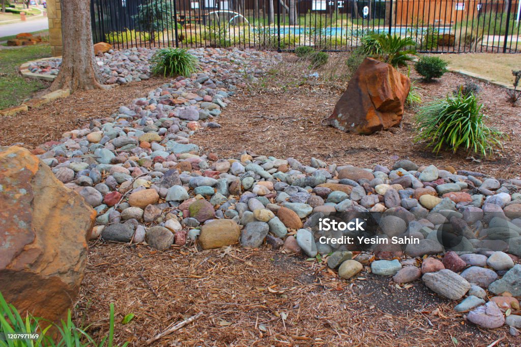 Landscaped garden with decorative stones, rocks and plants Landscaping with a dry stream and using river rock to accent garden Architecture Stock Photo