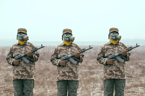 Soldados con máscara de gas y pistolas automáticas listas photo