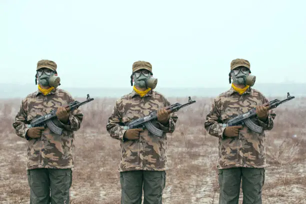 soldiers with gas mask and automatic guns standing ready