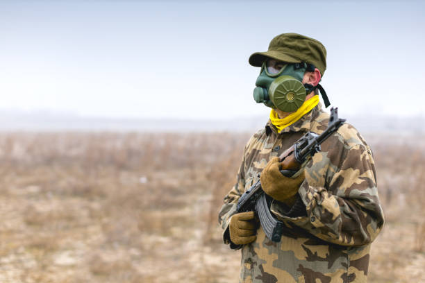istock Soldier with gas mask and automatic gun standing ready 1207971839