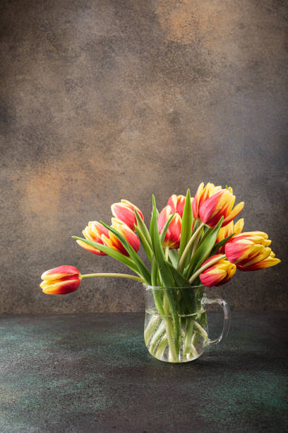 istock Red yellow tulips in glass vases 1207975097