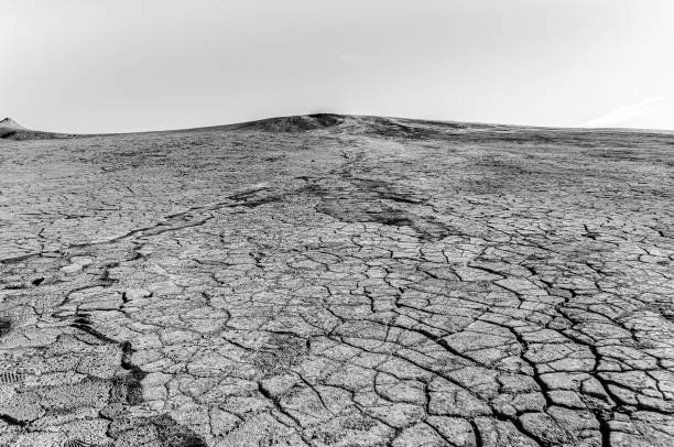 istock Mud volcano, dried soil with visible cracks, in monochrome 1207978303