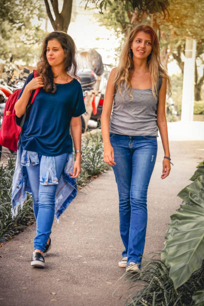 istock Two girls students walking to school. 1207980929