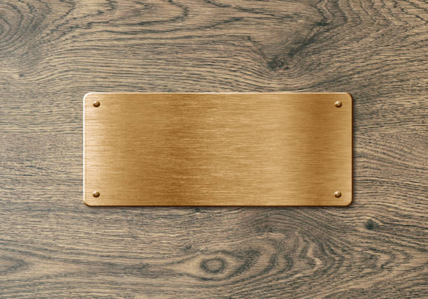 Blank polished golden colored name plate on wooden background to ad text, names or logos