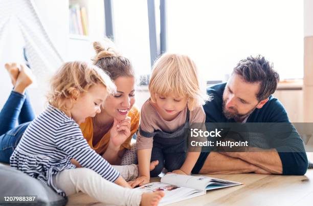 Junge Familie Mit Zwei Kleinen Kindern Drinnen Im Schlafzimmer Lesen Ein Buch Stockfoto und mehr Bilder von Familie