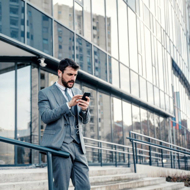 istock Businessman video chatting in city 1207989365