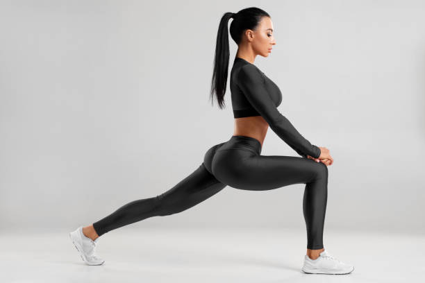 istock Fitness woman doing lunges exercises for leg muscle workout training. Active girl doing front forward one leg step lunge exercise for butt, isolated 1207990379