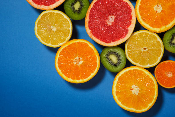 istock Assortment of various cut raw fruits on blue background 1208003991