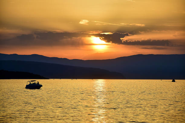 istock Sunset on an orange-gold sky with dark clouds. 1208005324