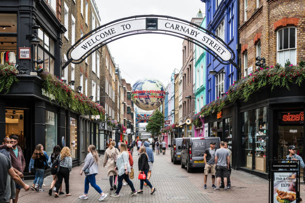 Early shoppers on the famous London Carnaby Street, a popular shopping street and tourist destination in London’s Soho with over a 100 shops and restaurants.