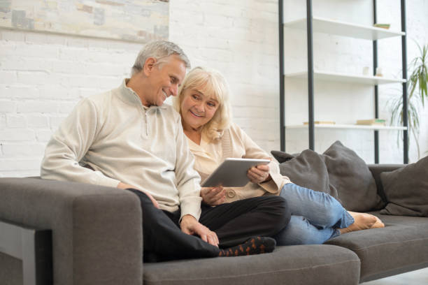 istock Happy mature man and woman using gadget at home 1208010044