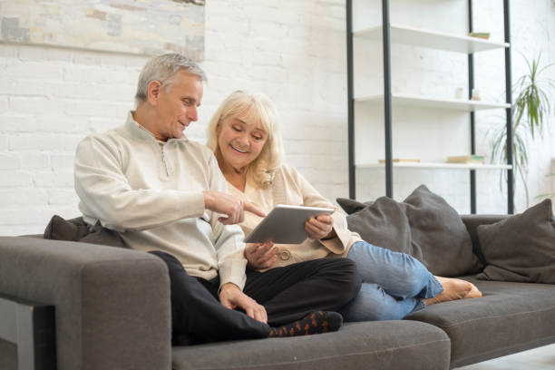 istock Happy mature man and woman using gadget at home 1208011289