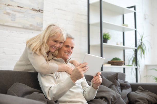 istock Happy old man and woman using digital tablet at home 1208012145