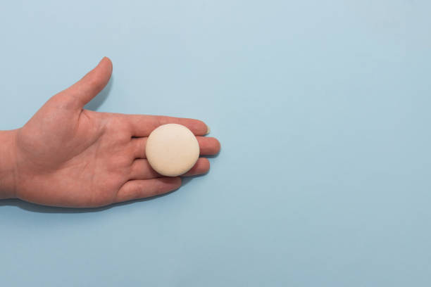 istock Macaroon cookie on female palm on blue flat background 1208012427
