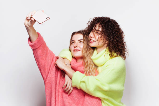 istock Two young beautiful women having fun together with taking a selfie 1208012739