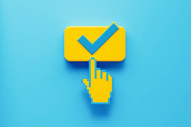 Hand Shaped Computer Cursor Clicking on A Yellow Push Button with Check Mark Hand shaped computer cursor clicking on a yellow computer button on blue background. Check mark is written on push button. Horizontal composition with copy space. Control concept. cursor photos stock pictures, royalty-free photos & images