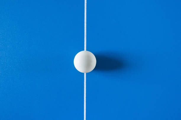 белый теннисный мяч для настольного тенниса на синем фоне. - table tennis table стоковые фото и изображения