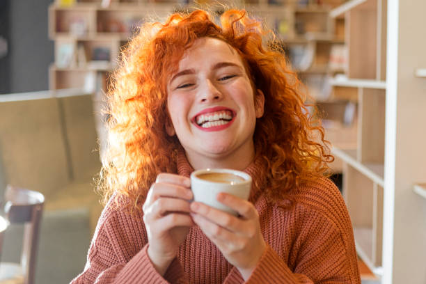 istock Young redhead woman drinking coffee smiling looking at camera 1208019887