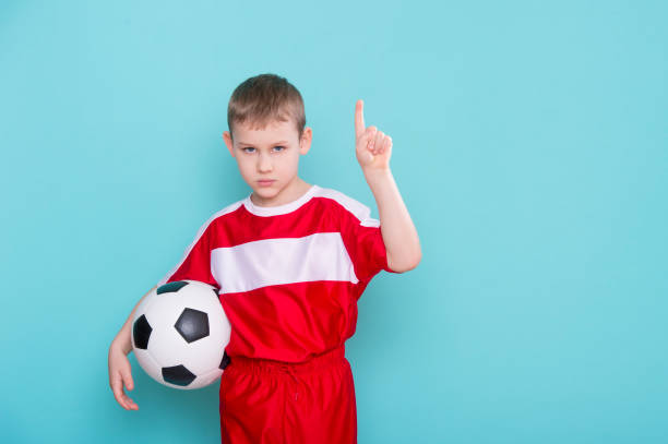 istock Boy With Soccer Ball On blue Background 1208021406