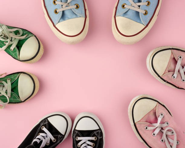 istock many multi-colored well-worn textile sneakers of different sizes on a pink background 1208022076