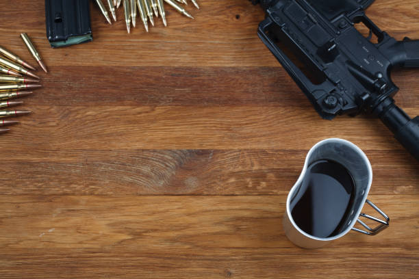 istock rifle and cup of coffee on wooden table 1208022327