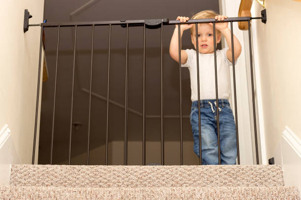 istock One year old blond boy next to the safety gate 1208022518