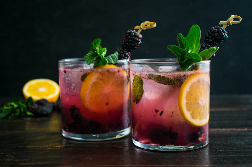 A sweet version of a gin and tonic cocktail made with fresh blackberries, mint, and Meyer lemon