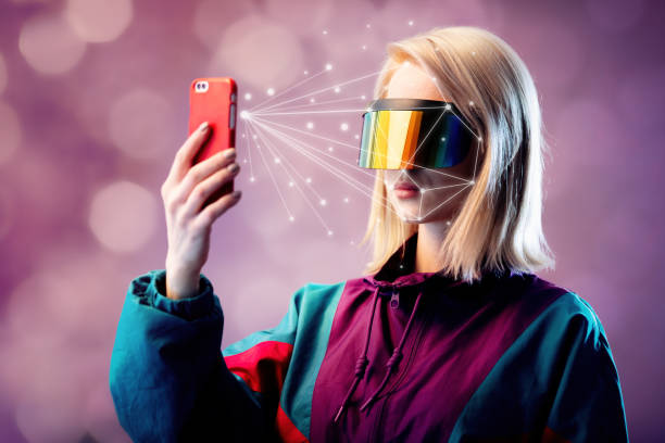 istock Blonde in VR glasses hold mobile phone with face scanning algorithm 1208033094