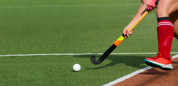 joueuse de hockey sur gazon passant à un coéquipier sur un terrain moderne et artificiel d’astroturf. - passing photos et images de collection