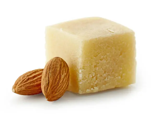 piece of marzipan and almonds isolated on white background, selective focus