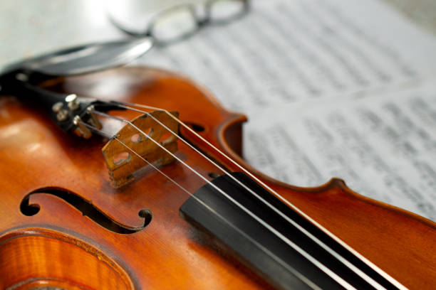 istock Violin and eyeglasses close up lying on the sheet music 1208040468