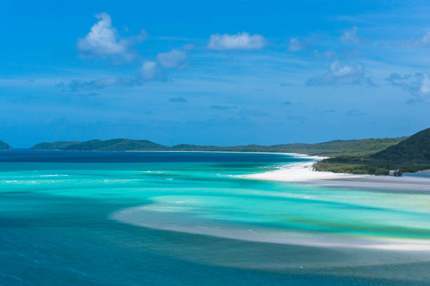 Beautiful tropical nature lagoon background with white sand beach, turquoise water and mountains in the distance. Summer tropical holiday scene