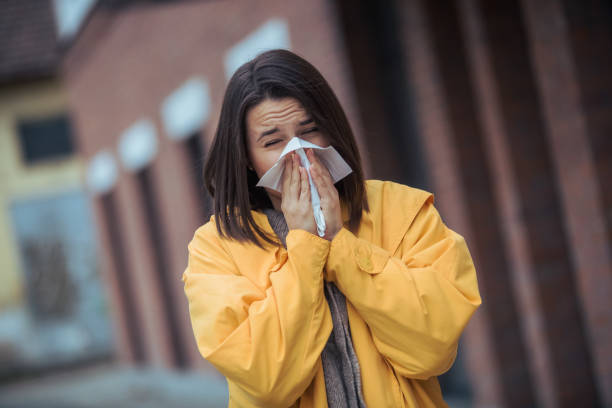 istock Sick young woman blowing her nose 1208045629