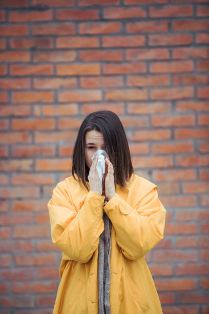 istock Sick young woman blowing her nose 1208045637