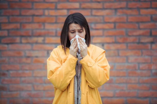 istock Sick young woman blowing her nose 1208045644
