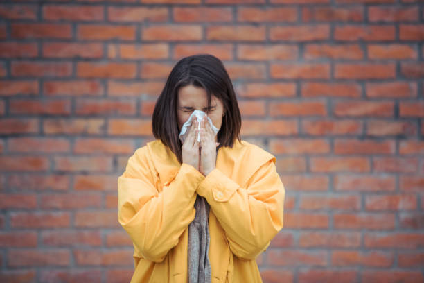 istock Sick young woman blowing her nose 1208045647