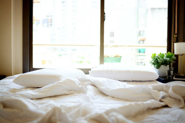 istock Bed in the morning with cell phone, book and glasses 1208045899