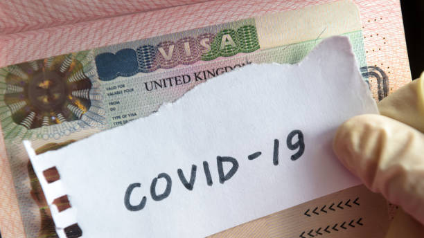 Coronavirus concept. Note COVID-19 coronavirus and UK visa in passport. Border control and quarantine of tourists infected with coronavirus.
