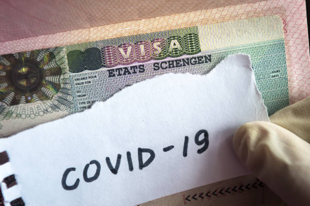 istock Coronavirus concept. Note COVID-19 coronavirus and Schengen visa in passport. Border control and quarantine of tourists infected with coronavirus. 1208050666