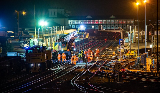 Network Rail workers can be seen working on the trackbed cutting out the temporary straight-lined track and replacing with the new rebuilt points. This work was required after a freight train derailment damaged the track.