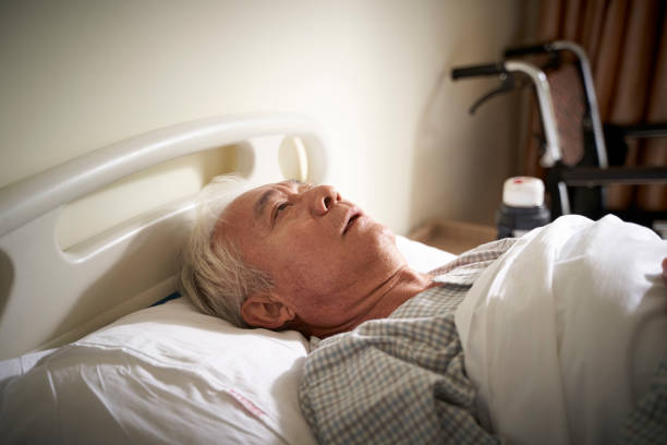 asian old man lying alone in hospital bed