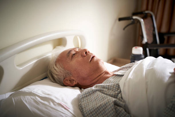 asian old man lying alone in hospital bed sick senior asian man lying in hospital bed appears to be sad and helpless hospital depression sadness bed stock pictures, royalty-free photos & images