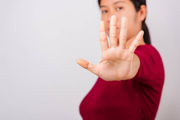 istock Asian beautiful woman itching her outstretched hand showing stop gesture front face, focus on hand 1208064815
